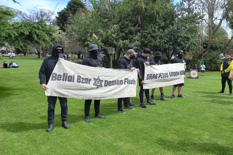 A group of neo-Nazis disturbed families at a youth festival in Melbourne on Friday morning by holding offensive signs and performing the Hitler salute